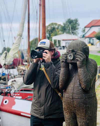 Martin mimiking a wooden figure that takes a picture.